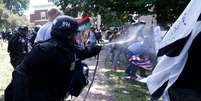 Policial usa gás de pimenta para separar grupos rivais  Foto: Reuters