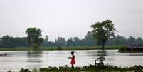 Menina carregando pratos em área alagada em Janakpur, no Nepal 13/08/2017 REUTERS/Navesh Chitrakar  Foto: Reuters