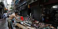 Homem limpa loja atingida pelo tufão Hato, em Macau 24/08/2017 REUTERS/Tyrone Siu  Foto: Reuters