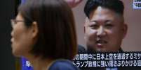 Pedestre em Tóquio passa diante de tela com imagem de Kim Jong-un  Foto: BBC News Brasil