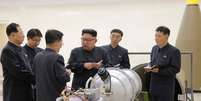 Líder norte-coreano (no centro) aparece perto ao lado da suposta nova bomba do país   Foto: BBC News Brasil