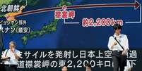 Cidadãos japoneses em frente a uma grande tela que mostra a trajetória do ultimo míssil norte-coreano  Foto: BBC News Brasil