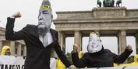 Pacifistas fazem protesto na Alemanha contra retórica de ameaças de Trump e Kim Jong Un, retratados com máscaras  Foto: BBC News Brasil