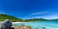 <p><strong>LOPES MENDES</strong></p><p>A praia queridinha dos surfistas é também a mais famosa da Ilha Grande: estamos falando de <strong>Lopes Mendes</strong>. Conhecida mundialmente, a praia possui 3 km de costa de águas cristalinas e agitadas. O destino é um dos mais procurados por quem visita a Ilha, mas não se preocupe: dificilmente a praia fica lotada. Para acessar esse paraíso, é possível realizar trilhas que saem da Ilha do Abraão ou barco seguido de uma trilha de 1 km.  </p>  Foto: Shutterstock / Guia da Semana