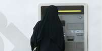 Mulher retira dinheiro em caixa automático na Arábia Saudita  Foto: BBC News Brasil