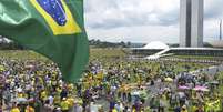pessoas usando roubas amarelas em protesto em frente ao Congresso, em Brasília  Foto: BBC News Brasil
