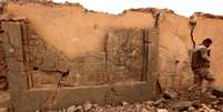 Um soldado caminha em meio a um artefato destruído em Nimrud   Foto: BBC News Brasil