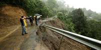 Moradores observam destruição causada pela tempestade em estrada local  Foto: Reuters