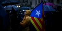 Manifestante segura bandeira separatista da Catalunha durante protesto em Barcelona, Espanha  Foto: Ivan Alvarado / Reuters