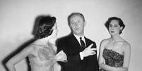 Dior e duas modelos vestidas com suas criações  Foto: Keystone / Getty Images