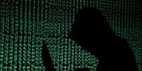 Pessoa usa computador diante de projeção de códigos cibernéticos
13/05/2017 REUTERS/Kacper Pempel/Illustration  Foto: Reuters