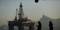 Pessoas passam por plataforma de petr&oacute;leo em Niter&oacute;i, no Rio de Janeiro 20/04/2015 REUTERS/Pilar Olivares  Foto: Reuters