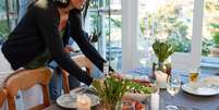 Decore os espaços vazios ao redor dos pratos com vasos de vidro, flores e velas  Foto: Shutterstock