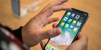 iPhone X na m&atilde;o de um homem  Foto: BBC News Brasil