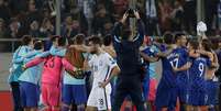 Croatas comemoram ao fundo a conquista da vaga para a Copa de 2018 enquanto jogador grego fica desolado  Foto: Reuters