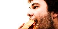 Homem comendo hamburguer  Foto: BBC News Brasil