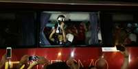 Jogadores do Independiente comemoram com a taça da Sul-Americana na janela do ônibus que foi quebrada (Foto: Igor Siqueira)  Foto: Lance!