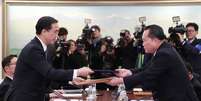 Líder da delegação norte-coreana, Ri Son Gwon, troca documentos com colega sul-coreano, Cho Myoung-gyon, após reunião bilateral no vilarejo de Panmunjom 09/01/2018 Yonhap via REUTERS  Foto: Reuters