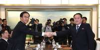 Representantes da Coreia do Sul e Coreia do Norte apertam as mãos durante reunião sobre os Jogos de Inverno  Foto: Reuters