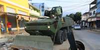 Veículo do Exército remove barreira instalada por criminosos na Vila Kennedy  Foto: José Lucena/Futura Press