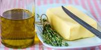 Garrafa com azeite de oliva e tablete de manteiga no pires  Foto: Shutterstock / TudoGostoso