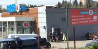 Policiais são vistos ao lado de supermercado onde homem mantinha reféns em Trèbes, na França  Foto: Reuters