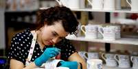 A worker prints a design onto a souvenir mug to commemorate the wedding of Britain's Prince Harry and Meghan Markle at the Emma Bridgewater Factory, in Hanley, Stoke-on-Trent, Britain March 28, 2018. Picture taken March 28, 2018. REUTERS/Carl Recine - RC130C39F310  Foto: Reuters