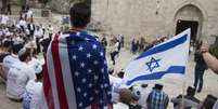A man wearing an American flag watch the flags march outside Damascus Gate on May 13, 2018 in Jerusalem, Israel.  Foto: Getty Images / BBC News Brasil