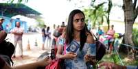 Venezuelana mostra passaporte e carteira de identidade em posto de controle de fronteira em Pacaraima, em Roraima
13/04/2018 REUTERS/Nacho Doce  Foto: Reuters