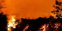 A lava da erupção do vulcão Kilauea atravessa rua no Havaí.  Foto: Marco Garcia / Reuters