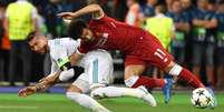 Sergio Ramos puxa Salah em lance que causou a lesão no atacante  Foto: Genya Savilov / AFP