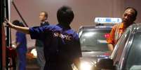 Funcion&aacute;rio abastece carro em posto de gasolina em Pequim, China 05/11/2010 REUTERS/David Gray   Foto: Reuters
