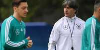 Joachim Löw, ao fundo, comanda treino com Özil (esq.) e Gündogan (dir.) já na Rússia  Foto: DW / Deutsche Welle