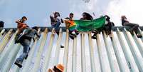 Com faixa que diz "diversidade sem fronteiras", cidadãos da América Central protestam em cerca entre EUA e México  Foto: DW / Deutsche Welle