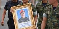 Militares tailandeses carregam quadro com fotografia de Samarn Poonan, ex-mergulhador de elite, morto nos esforços para resgatar um grupo de meninos e seu técnico presos numa caverna
06/07/2018
REUTERS/Panumas Sanguanwong  Foto: Reuters
