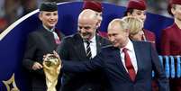 Putin toca o troféu da Copa ao lado do presidente da Fifa, Gianni Infantino  Foto: Damir Sagolj / Reuters