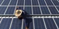 Homem limpa painéis solares que acionam máquinas de gelo na comunidade de Vila Nova do Amanhã, na Reserva de Desenvolvimento Sustentável, no Amazonas 22/09/ 2015. REUTERS/Bruno Kelly  Foto: Reuters