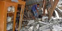 Aldeão caminha pelas ruínas de sua casa após terremoto atingir ilha da Indonésia  Foto: Antara Foto/Ahmad Subaidi / Reuters