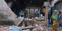 Mulher passa por destroços de parede destruída por forte terremoto em Lombok, na Indonésia 06/08/2018 Antara Foto/Ahmad Subaidi/ via Reuters  Foto: Reuters