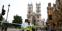 Policiais esperam em cordão em frente à Abadia de Westminster, próximo às Casas do Parlamento, onde possível atentado ocorreu  Foto: Hannah McKay / Reuters