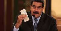 Presidente da Venezuela, Nicolás Maduro, segura nota da nova moeda do país, o bolívar soberano, durante reunião com ministros em Caracas 17/08/2018 Palácio de Miraflores/Divulgação via REUTERS  Foto: Reuters