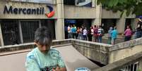 Pessoas formam fila para sacar dinheiro de caixas automático no banco Mercantil, em Caracas
21/08/2018
REUTERS/Carlos Garcia  Foto: Reuters