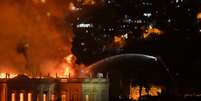 Bombeiro joga água sobre o Museu Nacional incendiado  Foto: Marcello Dias / Futura Press