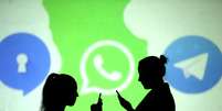 Pessoas utilizam celulares diande de projeção dos logos do Signal, WhatsApp e Telegram em foto ilustrativa
28/03/2018 REUTERS/Dado Ruvic  Foto: Reuters