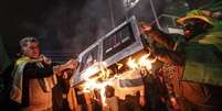 Eleitores de Bolsonaro queimam "urna eletrônica" em São Paulo  Foto: EPA / Ansa