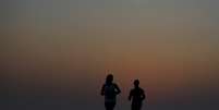 Mulheres correm durante o pôr do sol na praia da Barra da Tijuca, no Rio de Janeiro 20,/10/2015. REUTERS/Sergio Moraes   Foto: Reuters