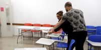 Funcionários preparam urna eletrônica em seção eleitoral em São Paulo  Foto: Paulo Whitaker / Reuters