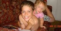 Paris, aos 10 anos, sorri e brinca com a irmã, Ella, então com dois anos de idade  Foto: BBC News Brasil