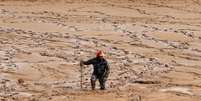 Membro da defesa civil busca pessoas desaparecidas após tempestades provocarem enchentes na cidade de Madaba, perto de Amman, na Jordânia  Foto: Muhammad Hamed / Reuters