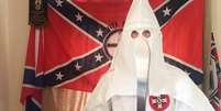 Thomas segura um facão vestido com o traje característico da Ku Klux Klan  Foto: W MIDS CTU / BBC News Brasil